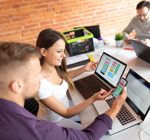 Un uomo e una donna sono intenti a lavorare su un laptop, mostrando un momento di collaborazione professionale.