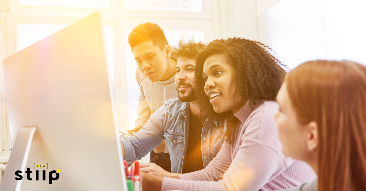 Immagine rappresentate un gruppo di ragazzi che lavorano davanti a un computer